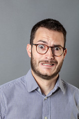 Obraz premium portret strachu przed skamieniałym młodym brodatym przedsiębiorcą zgrzytającym zębami