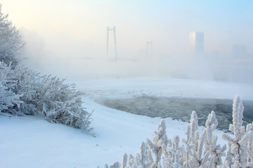 Зимний городской пейзаж. Мост в тумане над рекой...