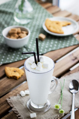 Glass with milkshake  and cookie in cafe.
