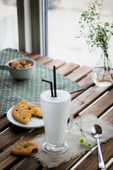 Obraz na płótnie Canvas Glass with milkshake and cookie in cafe.