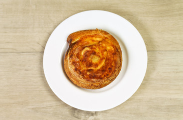 dessert bun with cheese at the white plate