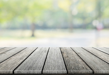 Empty wooden table with blurred city park on background, natural background with bokeh / spring concept