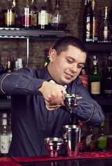 young man working as a bartender in a nightclub bar