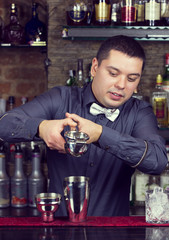 young man working as a bartender in a nightclub bar