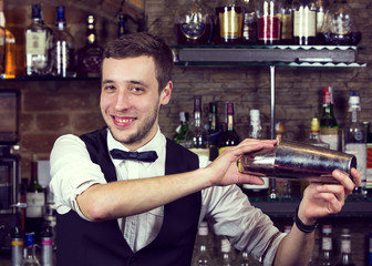 young man working as a bartender in a nightclub bar