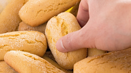 hand takes a traditional Italian biscuit 

