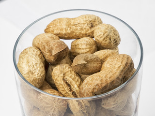 Cacahuetes en recipiente con fondo blanco