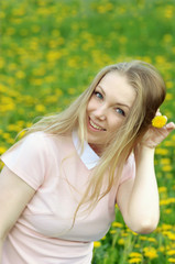 Obraz premium Image of pretty woman lying down on dandelions field.