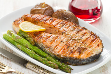 grilled salmon asparagus and potato on white dish on white background