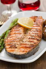 salmon with lemon and vegetables on white dish