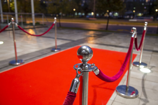 Red carpet between two rope barriers.