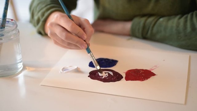Young Female Artist Designer Mixes Paint