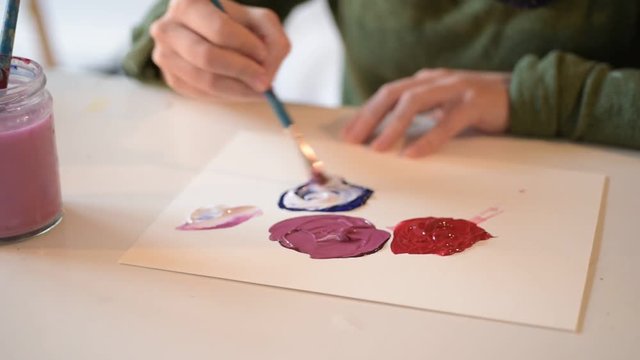 Young Female Artist Designer Mixes Paint