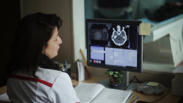 Experienced doctor looking at MRI scan of lumbar region on Monitor