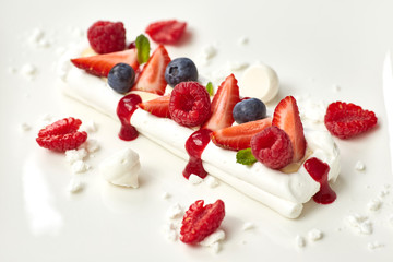 meringue cake decorated with fruit, strawberries, raspberries, b