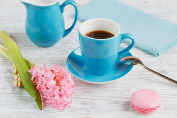 Cup of black coffee, pink flowers and french macaroons