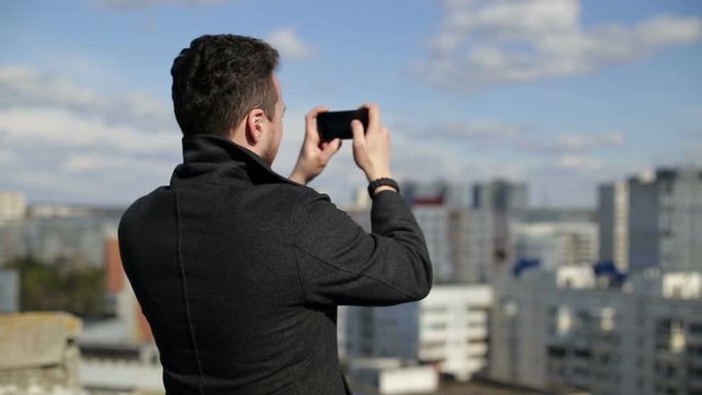 A man takes photos on the roof.