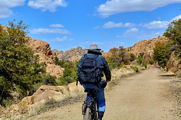 Naklejka premium Lone Bike Rider on Mountain Trail