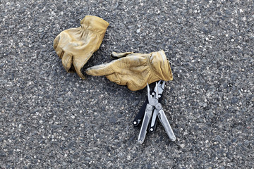 Man's Leather Work Gloves with Pliers on Asphalt