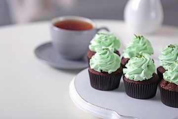 Beautiful chocolate cupcakes and cup of tea,  on table