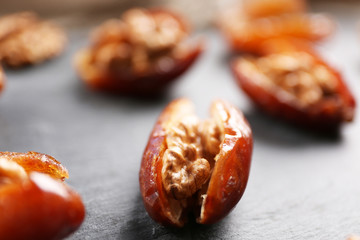 Walnut and date fruit on wooden table, close-up
