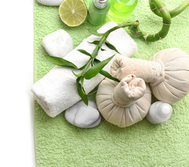 Relaxing spa set on green soft towel which lying on white background