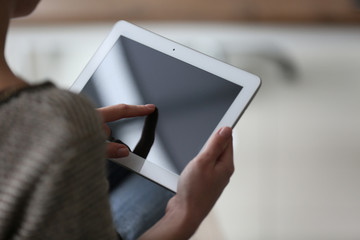Young woman using tablet on blurred background