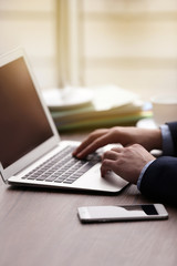 Man's hands using laptop at the table