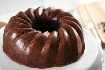 Chocolate cake on plastic mat on wooden background