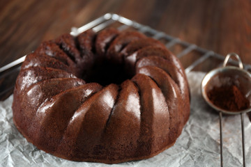 Chocolate cake on metal mat on wooden background