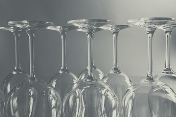 Wine glasses in a row upside down on light grey background