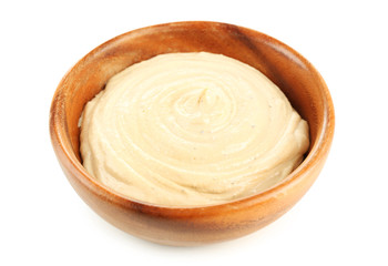 Wooden bowl of tasty hummus, isolated on white