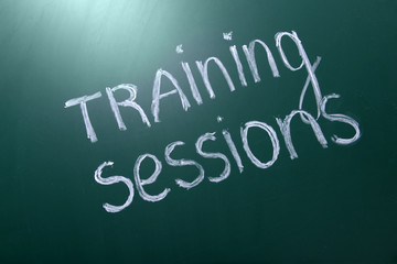 Obraz premium Training sessions inscription written with white chalk on blackboard