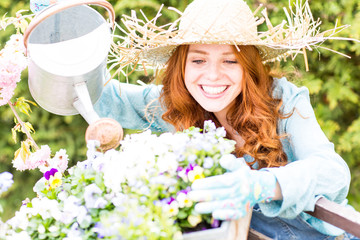 rothaarige Frau im Garten bei den Blumen
