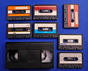 Fototapeta premium Set of old audio and video cassettes on blue background