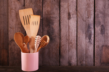 Utensil in pot on wooden background