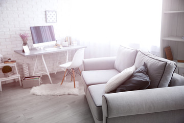 Modern interior. Comfortable workplace. Wooden table with beautiful bouquet of flowers and computer on it.