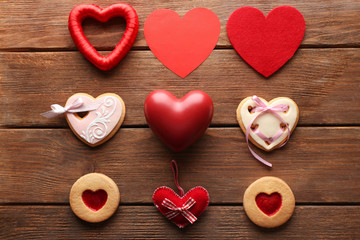 Fototapeta na wymiar Set of cakes and fabric hearts on wooden background