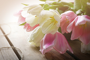Bouquet of pink and white tulips on wooden background