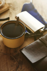 Cup of strong coffee with a flask on a wooden table, close up