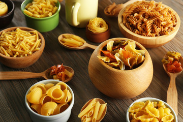 Various types of pasta in dishes, top view