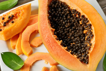Halved papaya with slices on a white plate