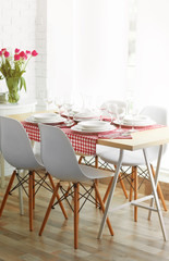 Table served with white dishes and a bouquet of tulips
