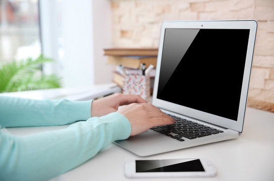 Woman working with laptop at home or at office