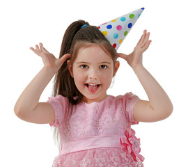 Little funny girl in birthday cap and pink dress, isolated on white