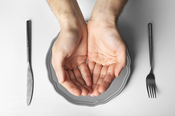 Male holding hands together over grey plate, isolated on white