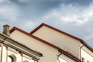 old houses with red roof under cloudy sky