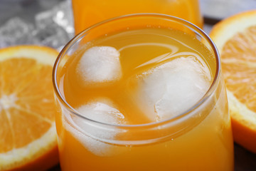 Glass of orange juice with ice, close up