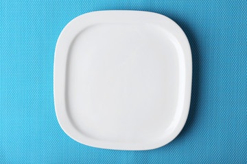 Empty plate on blue textured mat background