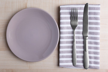 Empty plate with silver fork and knife on wooden background